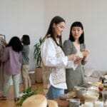 Kobiety przeglądające używane ubrania na wymianie w duchu slow fashion