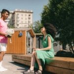 Mężczyzna wręcza kobiecie kwiaty podczas randki na świeżym powietrzu