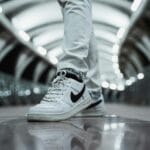 Białe sneakersy w zbliżeniu na tle nocnego, nowoczesnego miasta