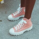 Różowe trampki high top na miejskim chodniku