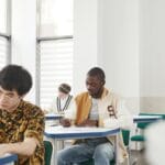 Studenci różnej narodowości piszą egzamin w sali na uczelni