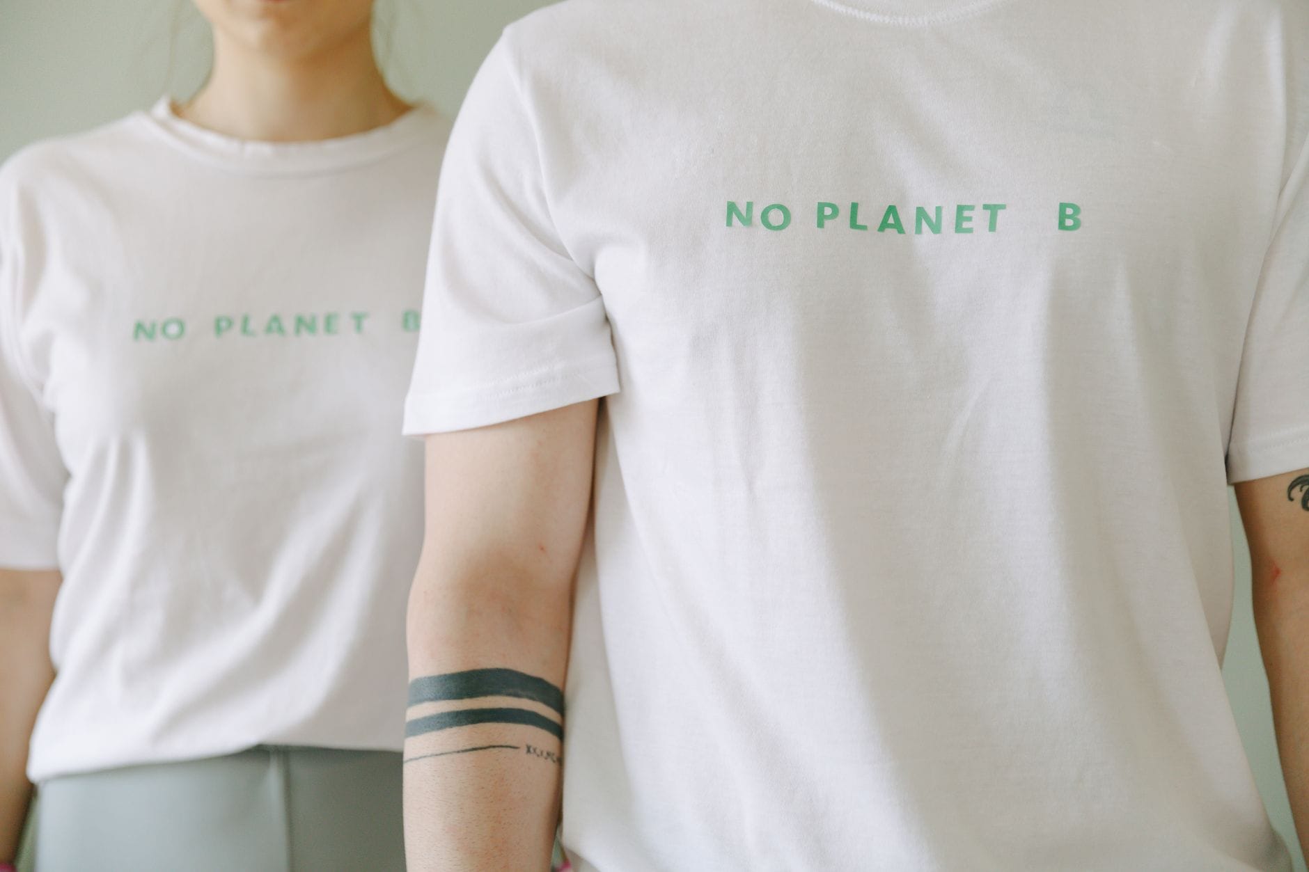 Dwie osoby w białych koszulkach z napisem No Planet B, moda odpowiedzialna Dwie osoby w białych koszulkach z napisem No Planet B, moda odpowiedzialna