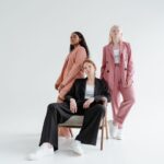 Kobiety w nowoczesnych garniturach pokazujące eleganckie stylizacje z sneakersam
