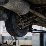Mechanik ogląda zawieszenie Mazdy 5 na podnośniku w warsztacie