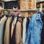Kolorowe kurtki vintage na drewnianym wieszaku w butiku