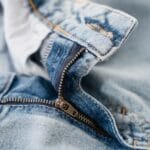 Zbliżenie na zamek błyskawiczny i szwy niebieskich jeansów damskich