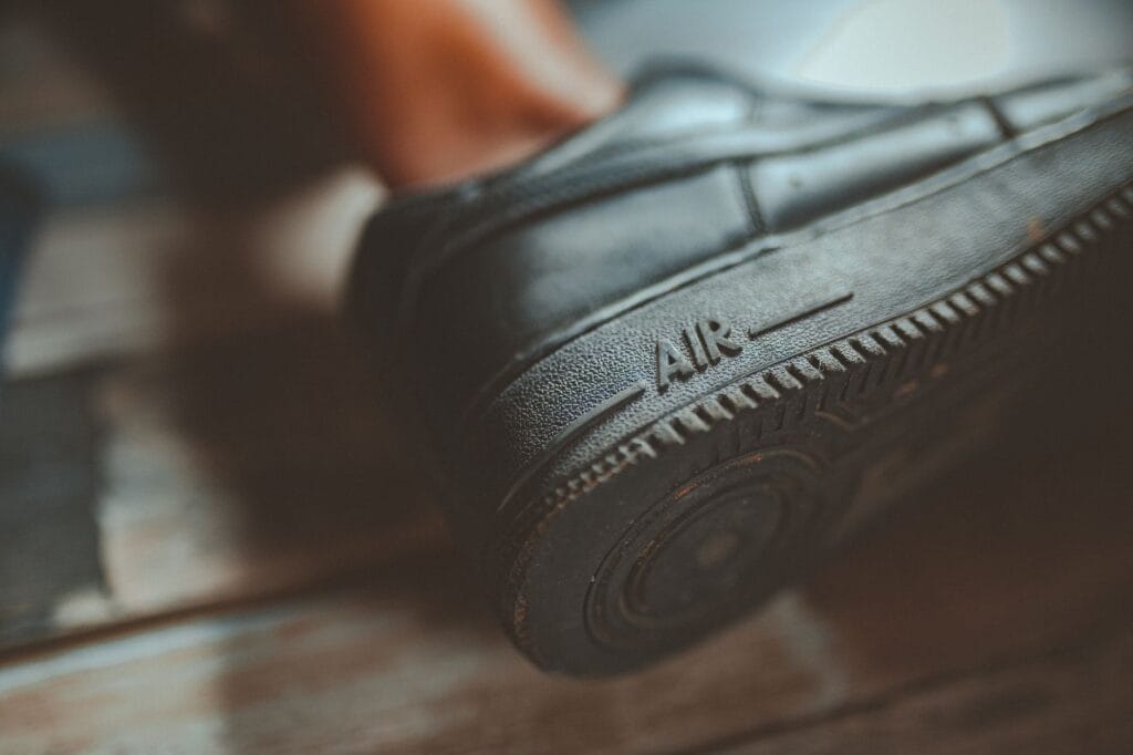 Zbliżenie na czarną gumową podeszwę sneakersa z napisem Air